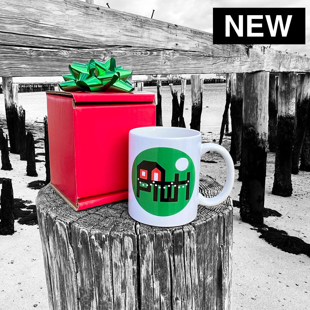 Two mugs with Provincetown Wharf Holiday designs on a wooden post and red box with a green bow.